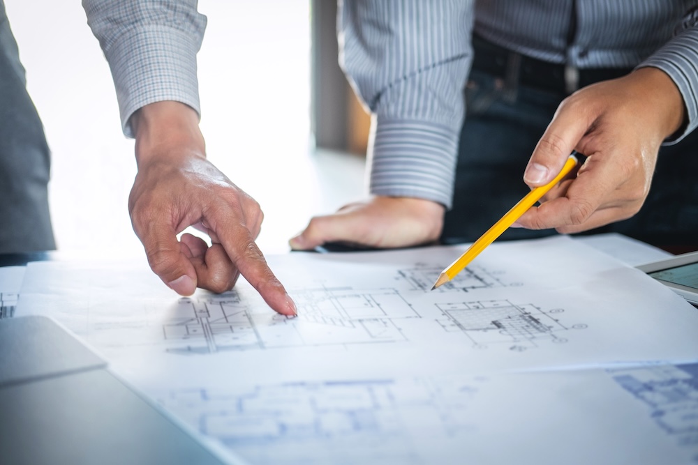 Hands of construction engineers as they discuss a blueprint